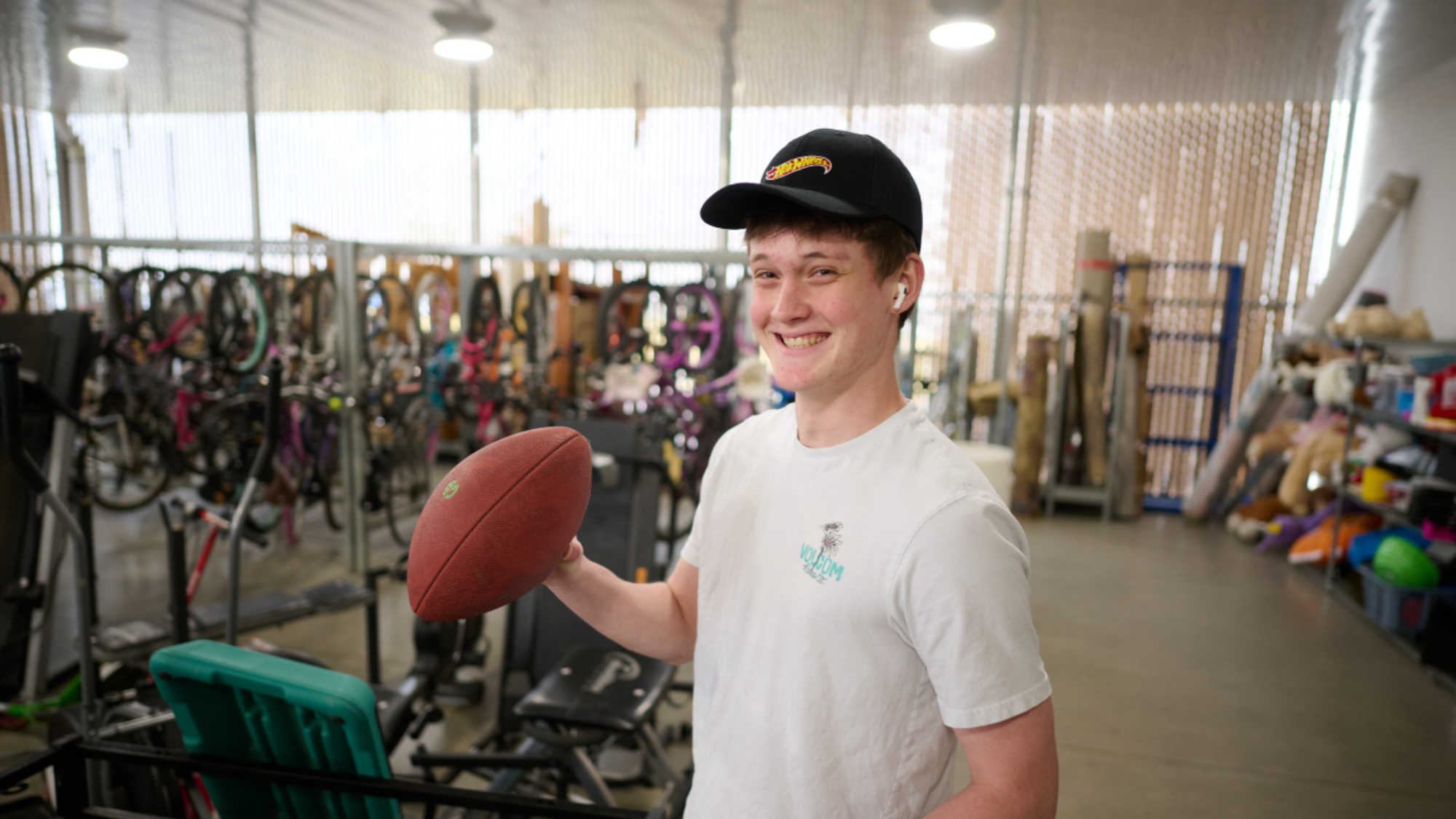 A DI shopper smiles as he finds a football in the store's yard area